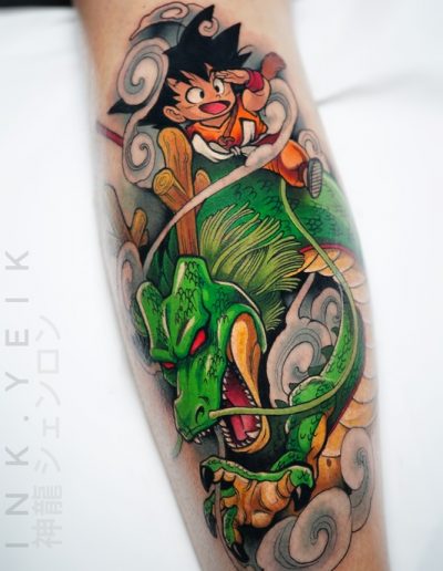Tatuaje a color de Shenron y Goku en estilo anime, con un diseño detallado y dinámico. La pieza destaca por sus colores vibrantes y sombreado preciso, creando un efecto visual impactante.