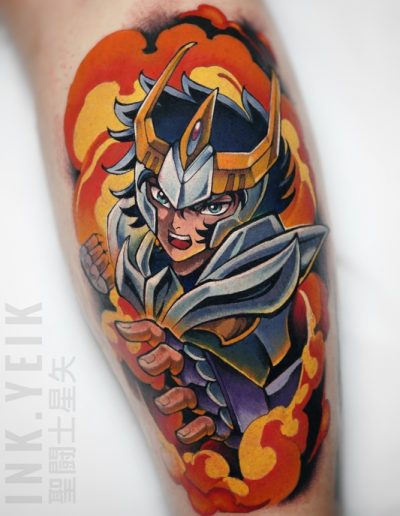 Tatuaje anime a color en Barcelona inspirado en Saint Seiya, con tonos vibrantes, efecto de fuego y un diseño lleno de dinamismo en Black Haru Tattoo Studio.