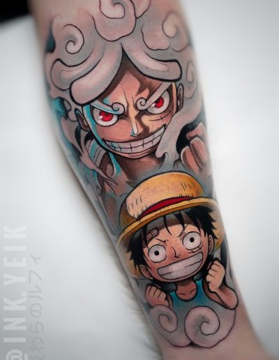 Tatuaje anime a color en Barcelona con un diseño vibrante de personaje icónico en dos versiones, rodeado de efectos de humo y expresiones intensas. Realismo y dinamismo en Black Haru Tattoo Studio.