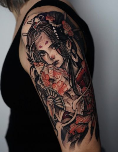 Tatuaje neojaponés en Barcelona con diseño de una geisha con abanico, detalles florales en tonos rojos y un estilo detallado en black & grey. Realizado en Black Haru Tattoo Studio.