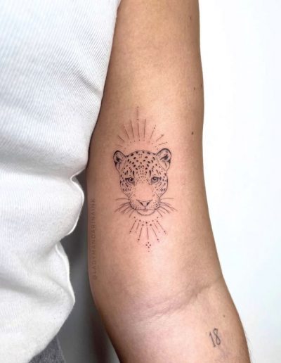 Tatuaje fineline en Barcelona con diseño minimalista de un leopardo con detalles geométricos en el antebrazo. Realizado en Black Haru Tattoo Studio.