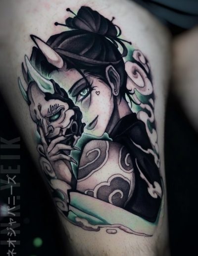 Tatuaje neojaponés en Barcelona realizado por Yeik en Black Haru Tattoo Studio. Diseño en black & grey con detalles en verde, representando una mujer con cuernos sosteniendo una máscara demoníaca.